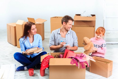 Professional furniture pick-up service in Kensington removing a sofa from a home